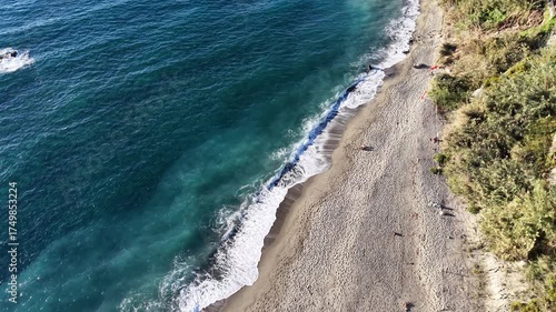Beautiful coastal waves drone shot of Ischia island in Italy with deep blue sea waves, cliffs and sunny weather. 
