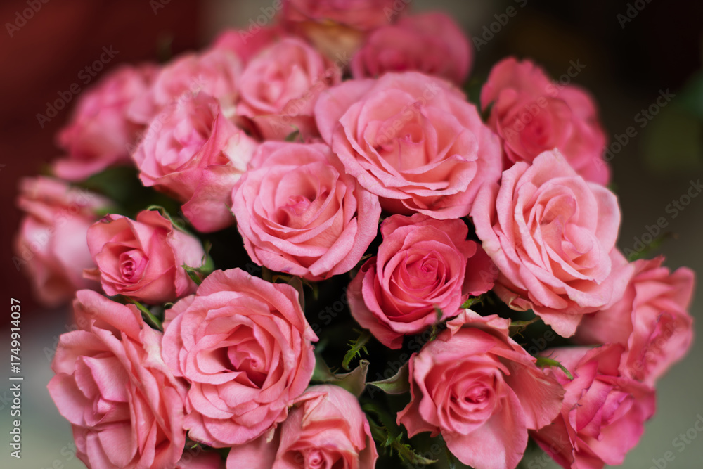Obraz premium A vibrant bouquet of fresh pink roses is captured in a close-up shot, showcasing their delicate petals and soft hues.