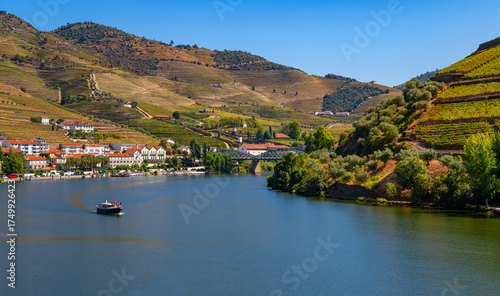 Scenic panorama of the landscape near Pinhão in the Douro Valley in Portugal in late summer from a train. Boat tours and cruises along the vineyards and villages are very popular on the wide river.