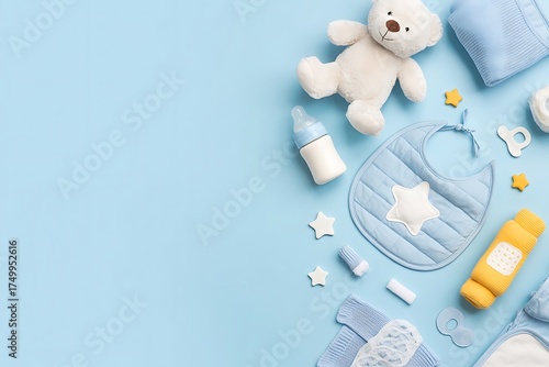 Flat lay of baby essentials including teddy bear bib bottle and blanket on blue background