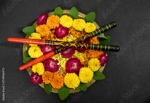 Traditional Brass Plate With Marigold, Roses, And Dandiya sticks at indoor