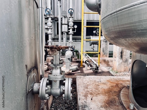 Fotografie Close-up of a heavy-duty industrial valve on a pipeline, surrounded by instrumentation and equipment at a chemical processing or oil and gas refinery plant