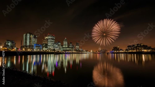Fireworks illuminate the London skyline at night over the River Thames.