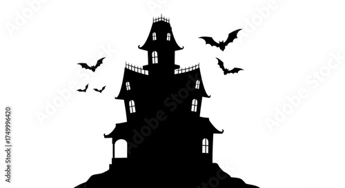 Silhouette of a spooky haunted mansion on a hilltop with flying bats perfect for halloween themed designs and decorations isolated on white background