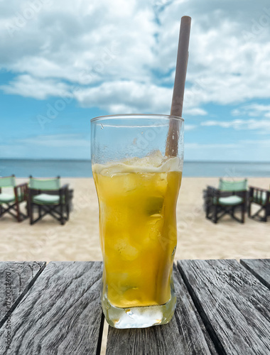A glass of a drink with a straw in it.