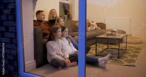 Happy family at home sitting on the sofa and watching tv