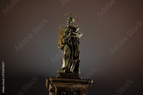 Statue of John of Nepomuk, Charles Bridge, Prague, Czech Republic, Czechia. Sculpture of saint historical person. Historic monument and landmark. Baroque artwork from 17th century. Copy space.