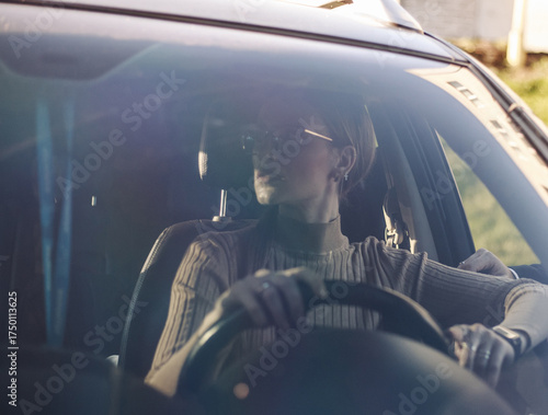 Woman driving car, looking nervously to the right, view through the windshield