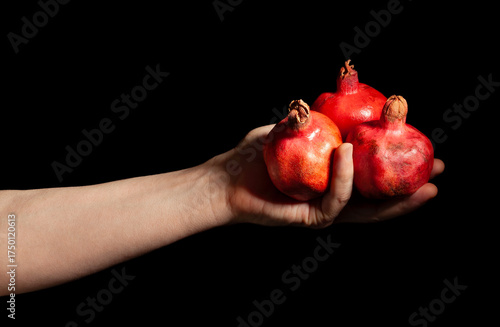 pomegranate in hand isolated on black