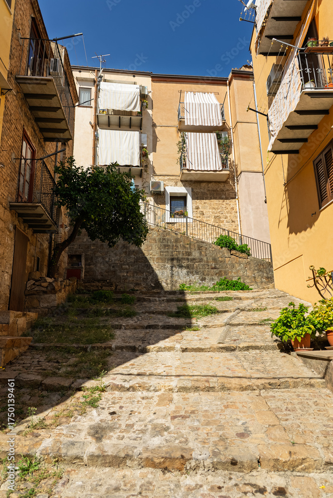 Fototapeta premium Castelbuono medieval town in the Madonie Mountains, Sicily, Italy, basking under the summer sun with historic streets, Ventimiglia Castle. Old mountain town in Sicily. Italian town in hills