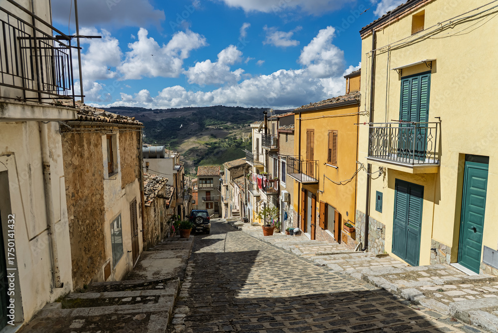 Obraz premium Caltavuturo, a historic Sicilian mountain town in the Madonie Mountains, featuring its medieval castle, charming narrow streets, and traditional stone houses, Sicily, Italy. Italian town in hills