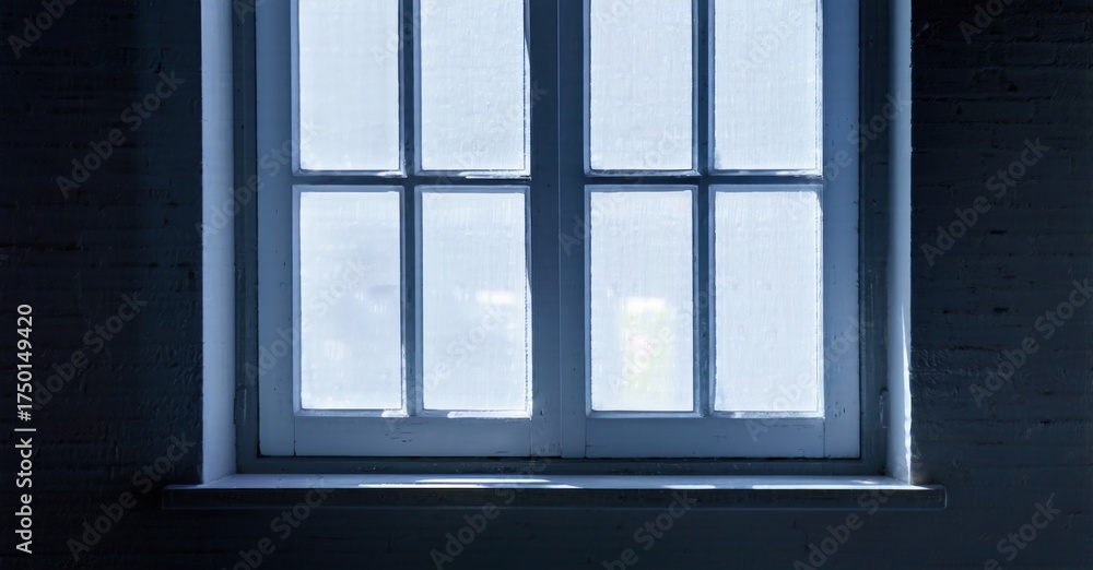 Fototapeta premium Dark room features window. Light shines through panes, creating contrast. Brick wall surrounds frame, simple composition.