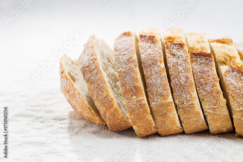 Rustic bread cut into slices on a white background
