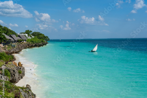 Fototapeta Traditional wooden dhows anchored near the shore in Nungwi, Zanzibar, with turquoise waters and clear skies