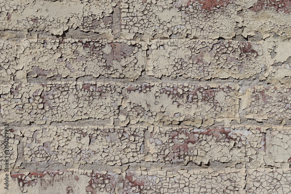 Fototapeta premium Old outdoor wall with chipped paint on the bricks.Wall repair and paint. Damaged outdoor wall and construction industry.