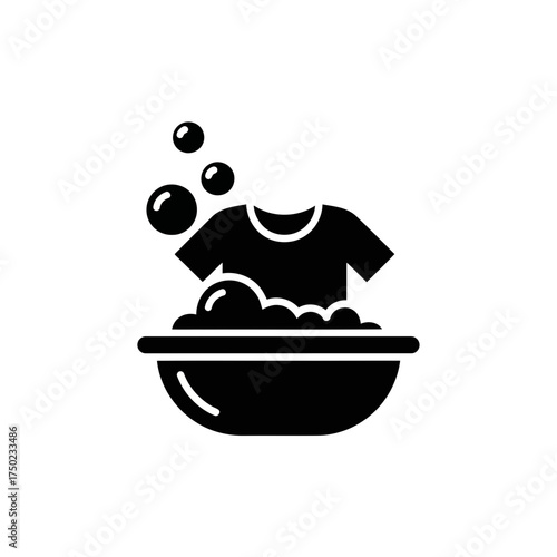 Black icon of a tshirt being washed in a basin with soap bubbles and water