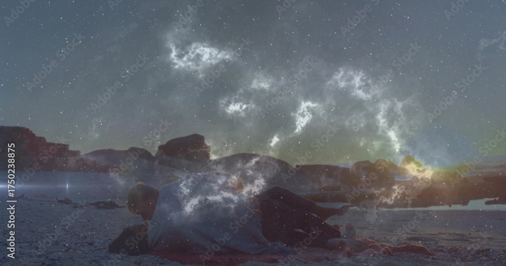 Naklejka premium Hugging couple lying close together on sandy beach shore at dusk, with small blanket