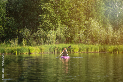 A woman sup surfing paddling on a boat on a river on sunny day: Abakan, Russia - June 08, 2024