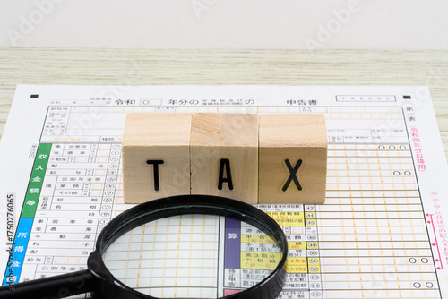 確定申告書と虫眼鏡で税務調査のイメージ