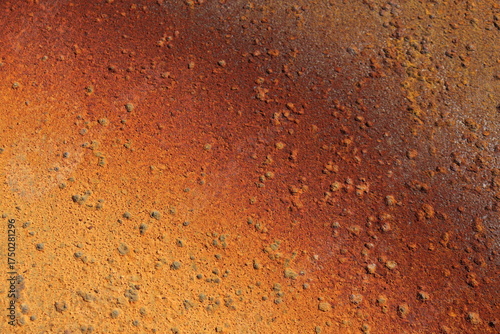 Rusty metal background in brown, red and orange colors. Rusty métal with particles and texture. Grainy rust and construction industry. Canvas and pattern in metallic texture.