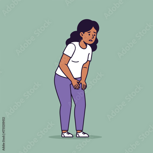 Woman with dark hair clutching her knee in discomfort, looking down sadly