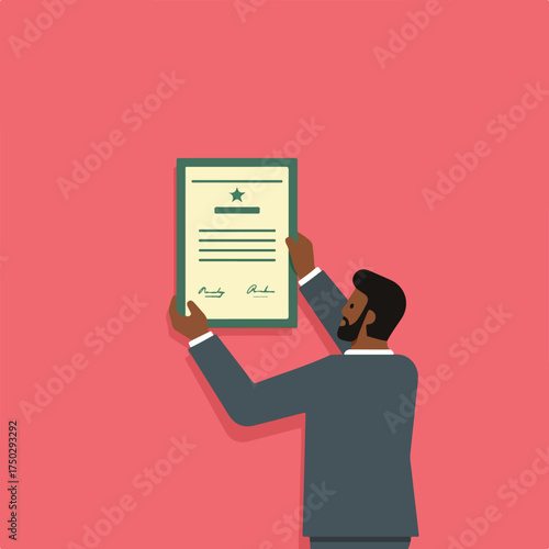 Man in suit holding up certificate with star and signatures