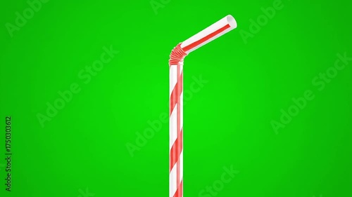 Brightly striped drinking straw bends against a vibrant green background, perfect for summer refreshment
