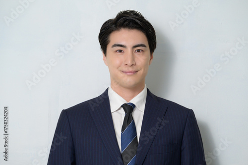 白背景で微笑む日本人男性