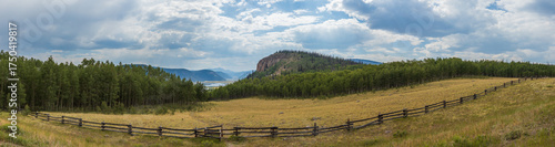 mountain meadow panorama with distant sun rays