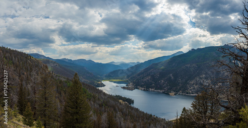 Sun rays over mountain lake with dramatic sky