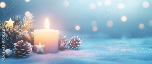 A soft blue background with a large, lit candle in the center, surrounded by Christmas decorations like small white stars and pine cones
