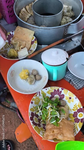 Preparing meatballs in a bowl at a meatball vendor's cart. Meatballs are a popular food in Indonesia.