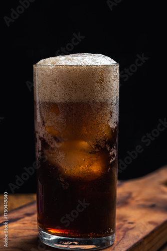 Real photo, not AI, of a glass with Fernet with cola, a traditional drink from Cordoba, Argentina, based on herbs and soda. Served 70/30 with ice.