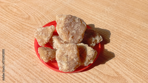 Brown sugar jaggery isolated on wooden background.