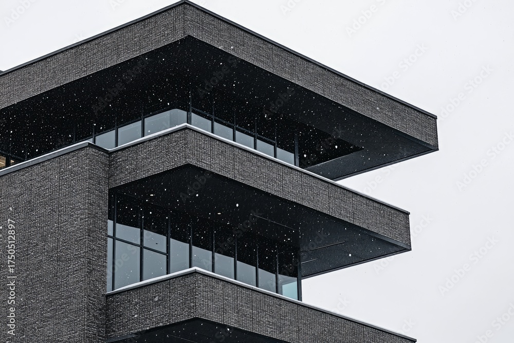 Fototapeta premium Modern, dark gray building with layered, geometric balconies and windows