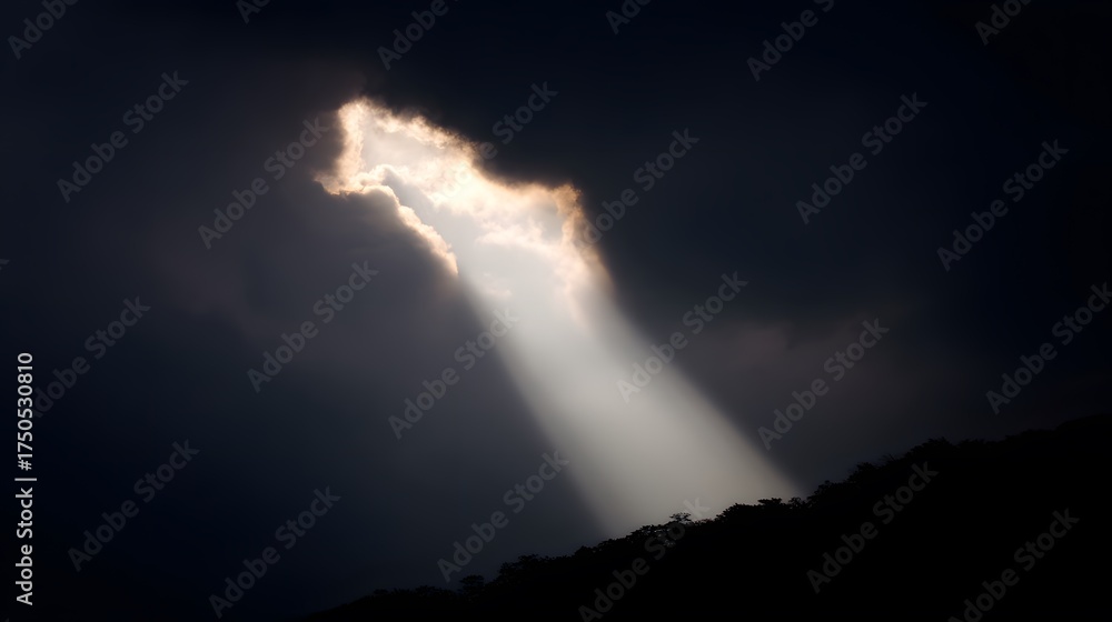 Obraz premium Beam of sunlight breaking through dark storm clouds, illuminating the ground.