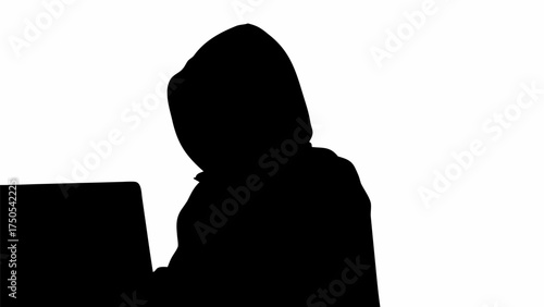 Mysterious hooded figure silhouetted working on laptop, conveying digital privacy and cybersecurity concerns