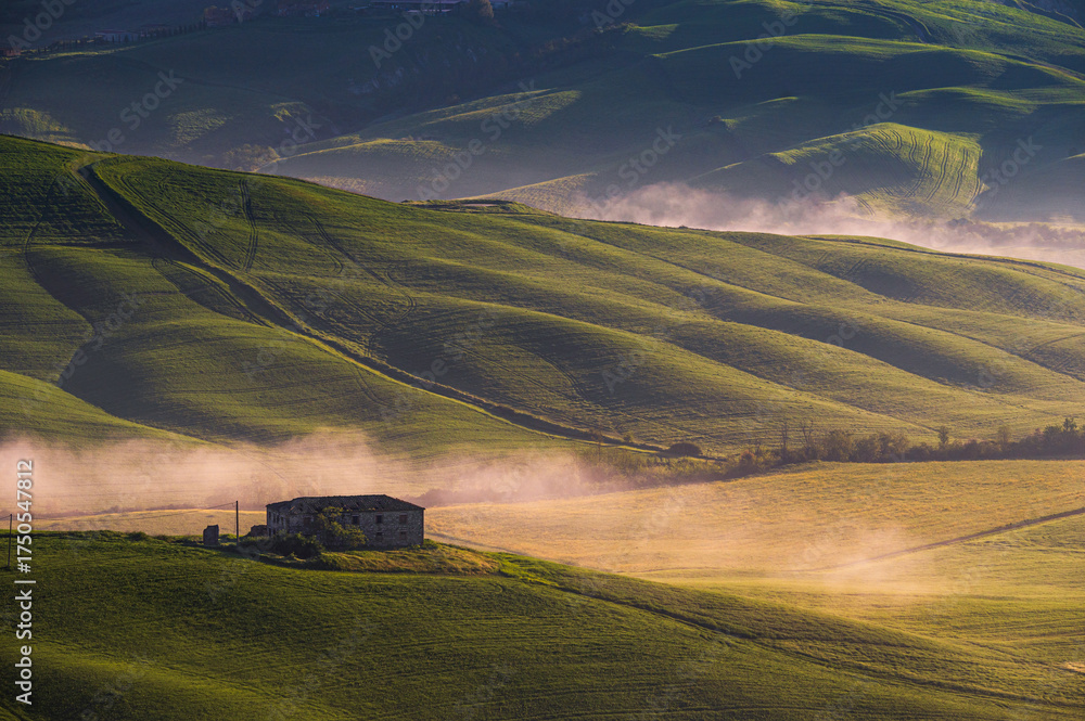Obraz premium spring sunrise over the Tuscany hills with a farm house inside the valley, Italy