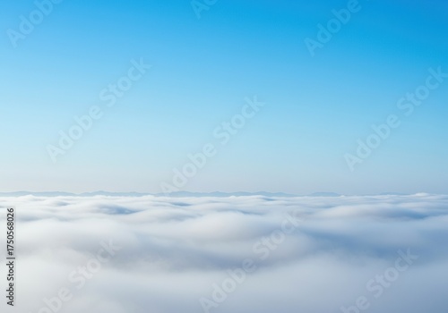 Dense morning fog slowly dissipates, revealing a serene, vibrant blue sky above. A peaceful, cool atmosphere with a soft, ethereal glow ,aerial ,sky ,diffuse