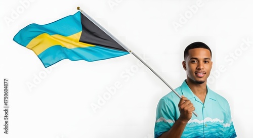 Happy young Bahamian man proudly holding the national flag of The Bahamas on a white background, celebrating his heritage and patriotism