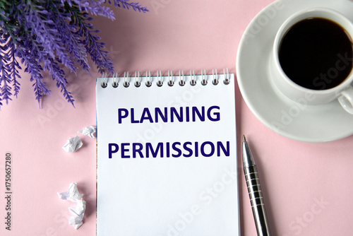 PLANNING PERMISSION - words in a notebook on a pink background with a cup of coffee