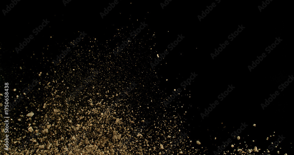 Obraz premium Detailed wave of airborne clay dust swirling in chaotic motion, captured in freeze motion. Dramatic natural explosion of earthy particles on black background.