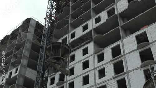 Tower crane lifting concrete bucket at construction site