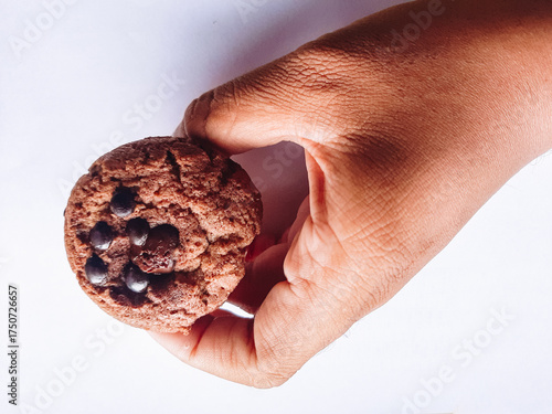 Hands holding chocolate chip muffins with delicious treats in the background. Birthday concept