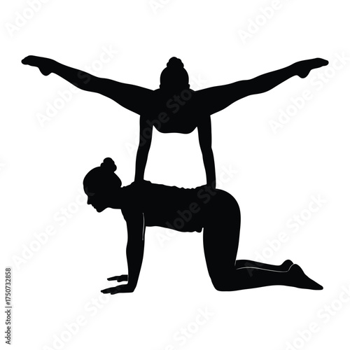 Silhouette of two women performing acrobatic yoga pose with one balancing on the other's back