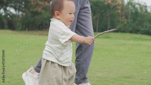 Teaching an Asian baby to walk on the grass