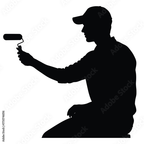 Silhouette of a painter with a cap holding a paint roller at arm's length while kneeling down