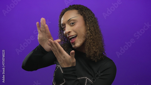 Vászonkép Transgender hispanic woman makes money gesture with fingers in a purple studio set; greed wealth desire