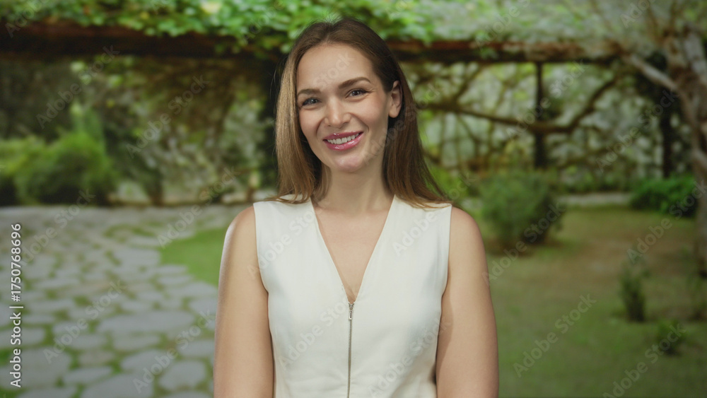 Naklejka premium Woman smiling showing bare shoulder in forest setting with soft daylight and leafy canopy; serenity.
