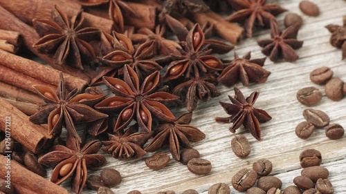 Slow Motion Rotation of Cinnamon Sticks, Star Anise and Coffee Beans on Wooden Surface with Warm Brown Aromatic Spices Background